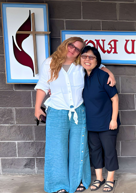 two people embrace in front of church