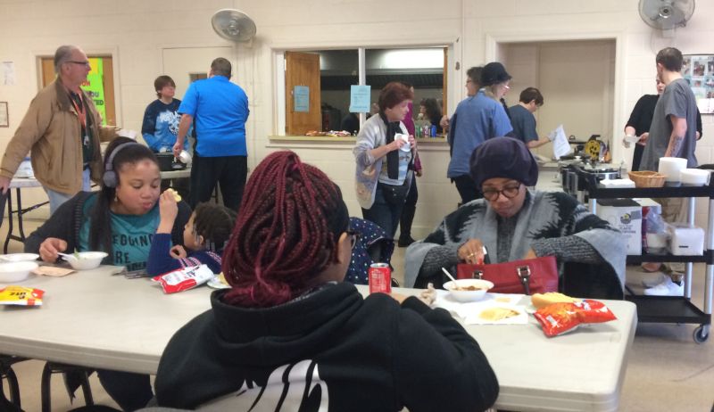 people sitting around a table, eating