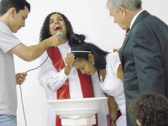 the author baptizes an adult, with a look of joy