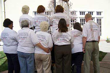 back of group, all with shirts showing Committee name and Advance logo