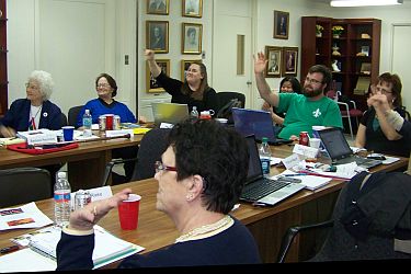 group voting by raising hands, around table